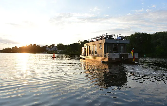 Hauptstadtfloß – Modernes Hausboot bei Sonnenuntergang